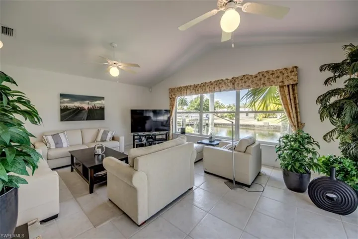Living area with a ceiling fan and light tile patterned floors