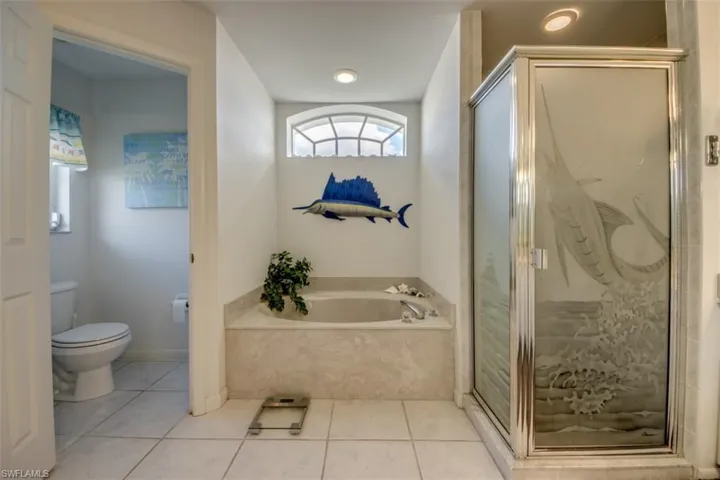 Full bath with a bath, a marble finish shower, and light tile patterned flooring