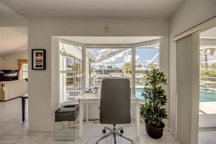 Office area featuring light tile patterned flooring and baseboards