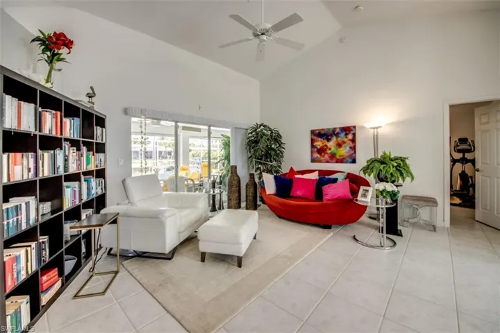 Sitting room featuring lofted ceiling, light tile patterned floors, and a ceiling fan