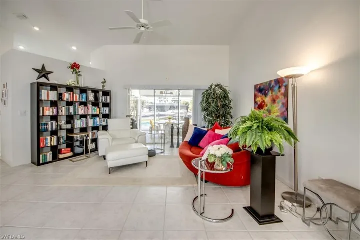 Living area with ceiling fan, light tile patterned floors, vaulted ceiling, and recessed lighting