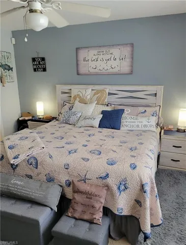 Carpeted bedroom featuring ceiling fan