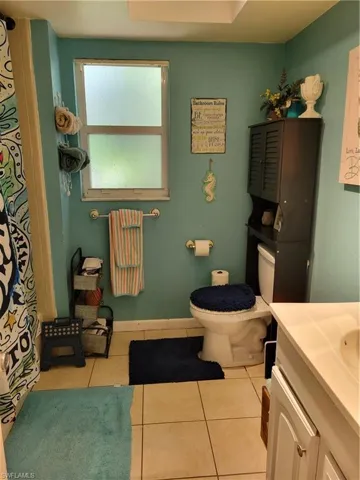 Bathroom featuring vanity, toilet, and tile floors