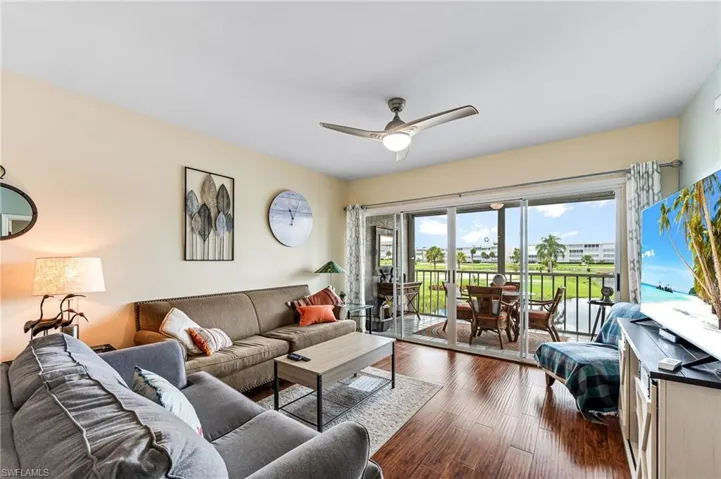 Living room featuring dark hardwood / wood-style floors and ceiling fan