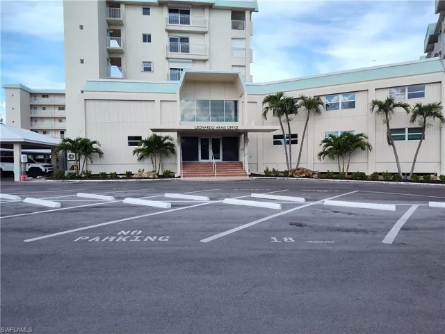 View of building exterior featuring uncovered parking