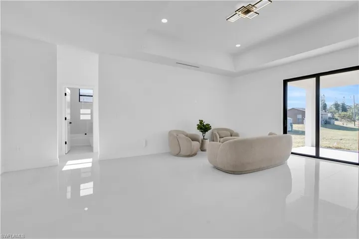 Living area featuring recessed lighting, tile patterned flooring, baseboards, and a raised ceiling