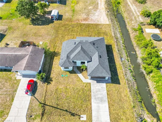 Birds eye view of property with a water view