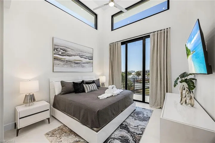 Bedroom with multiple windows, access to exterior, and a towering ceiling - Virtually Edited Image