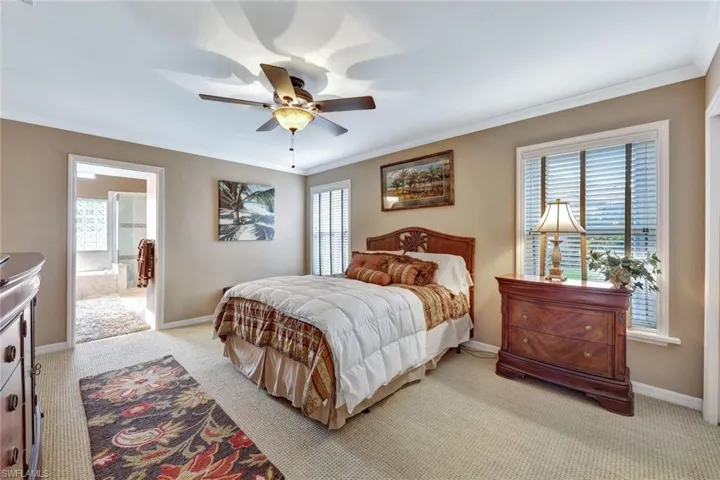 Spacious Lower level Master Suite features neutral carpet, crown molding, and ceiling fan.