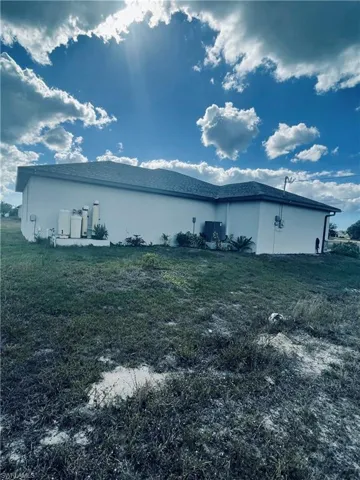 View of side of property featuring a yard and stucco siding