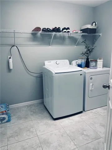 Laundry area with baseboards and washer and dryer