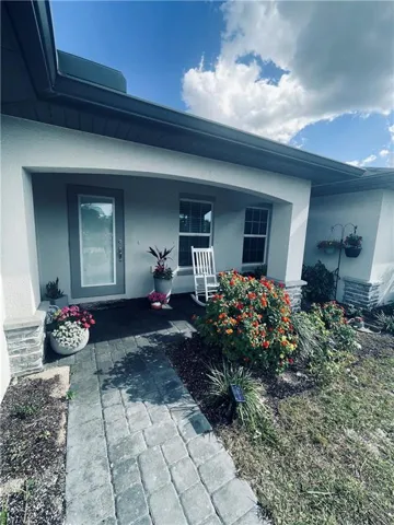 Entrance to property with stucco siding and a porch