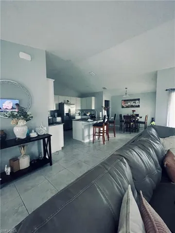 Living area with lofted ceiling and light tile patterned floors