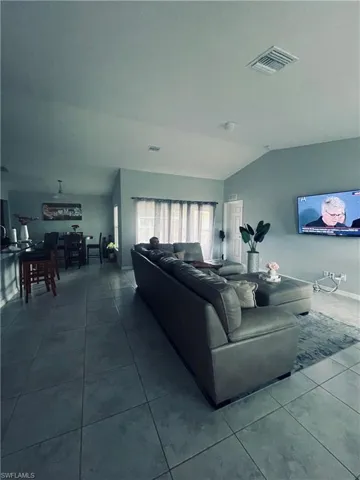 Living area with lofted ceiling and tile patterned flooring