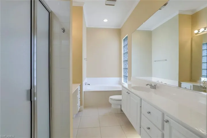 Full bathroom with tile floors, ornamental molding, oversized vanity, and toilet