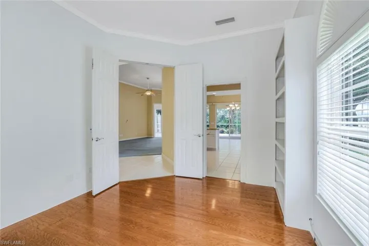 Unfurnished room with ornamental molding, light hardwood / wood-style floors, and ceiling fan with notable chandelier