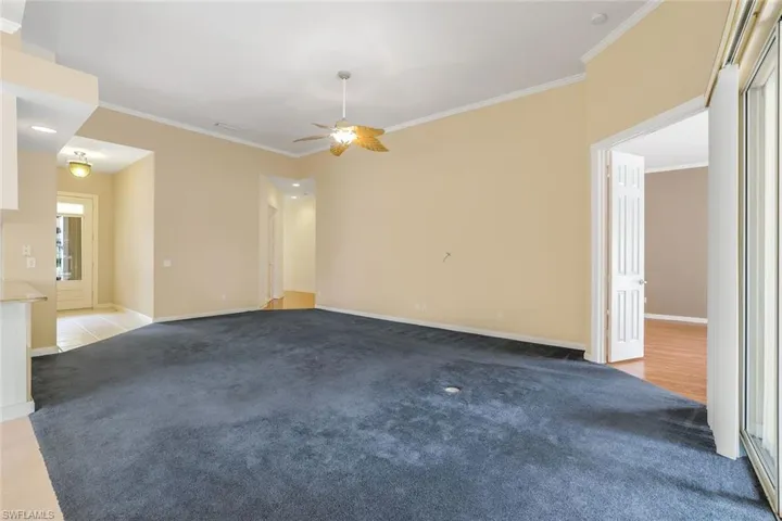 Tiled spare room with ceiling fan and crown molding