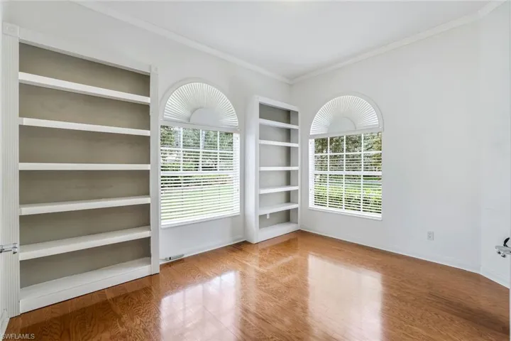 Spare room featuring ornamental molding and hardwood / wood-style flooring