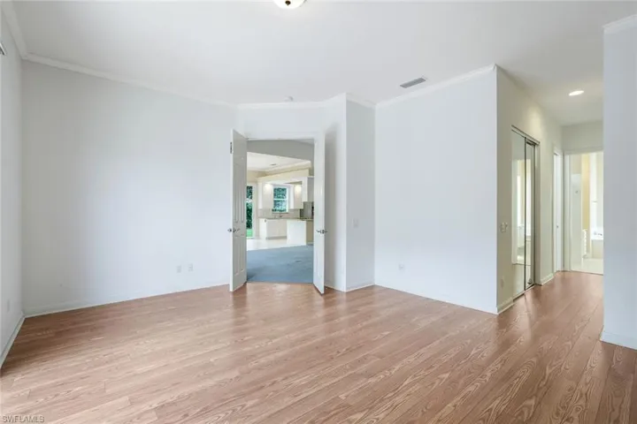 Empty room with wood-type flooring and ornamental molding