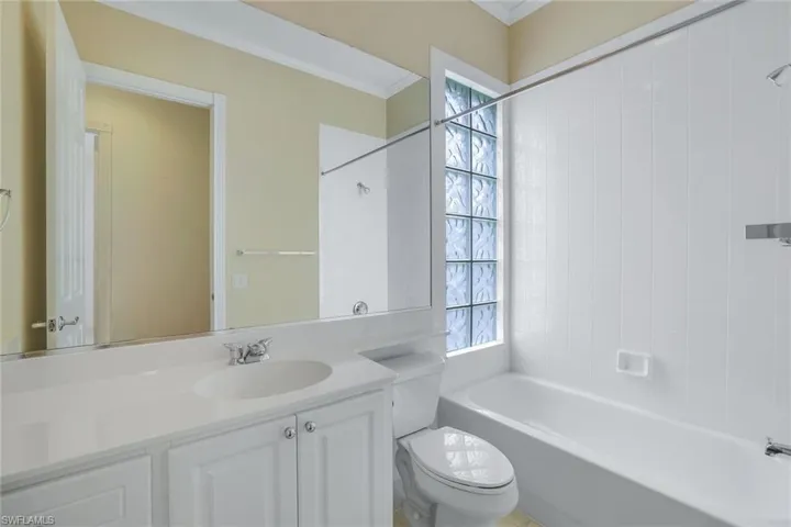 Full bathroom featuring crown molding, tiled shower / bath combo, vanity, and toilet