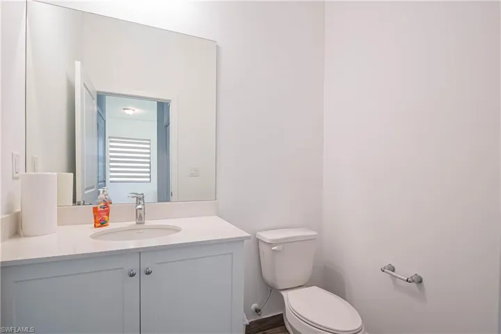 Half bathroom featuring vanity and toilet