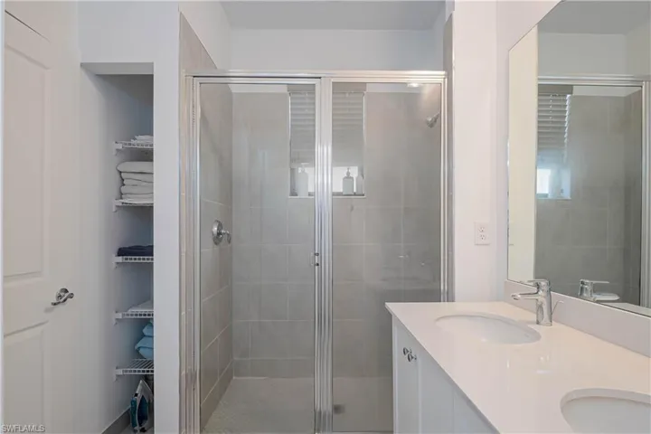 Full bath with a stall shower and double vanity