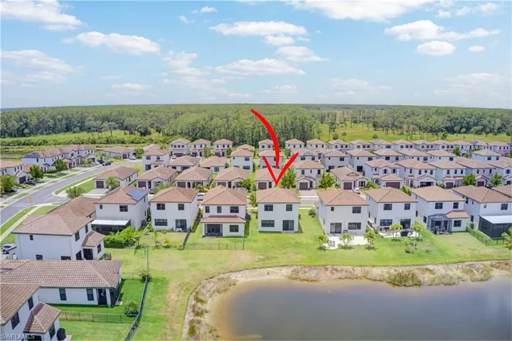 Aerial perspective of suburban area featuring a nearby body of water