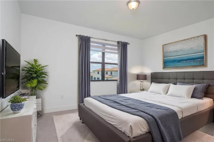 Bedroom with baseboards and light carpet