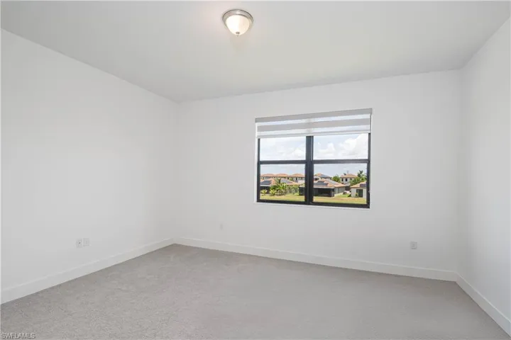 Unfurnished room featuring light colored carpet and baseboards