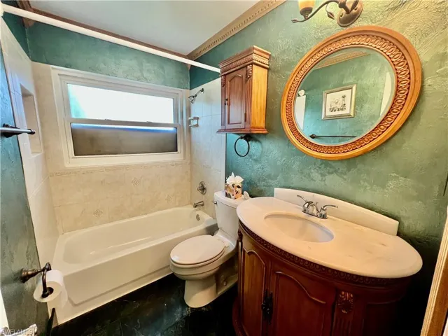 Full bath featuring bathing tub / shower combination, vanity, and toilet