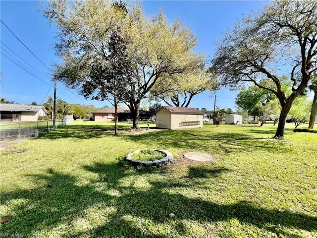 View of HALF ACRE backyard with shade trees.