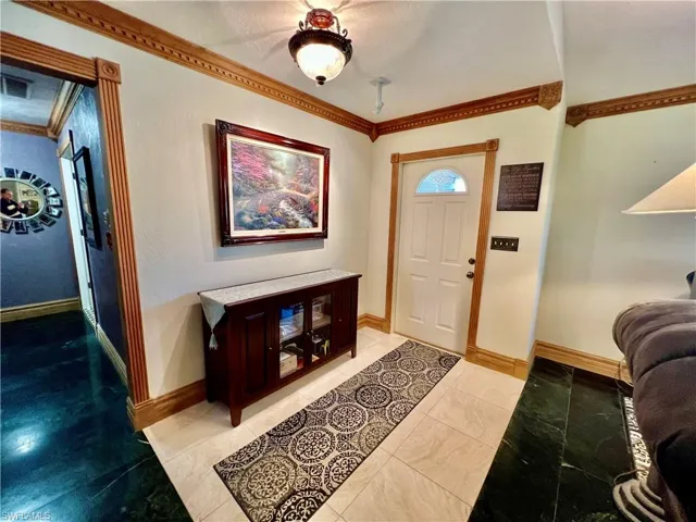 Foyer featuring baseboards and ornamental molding