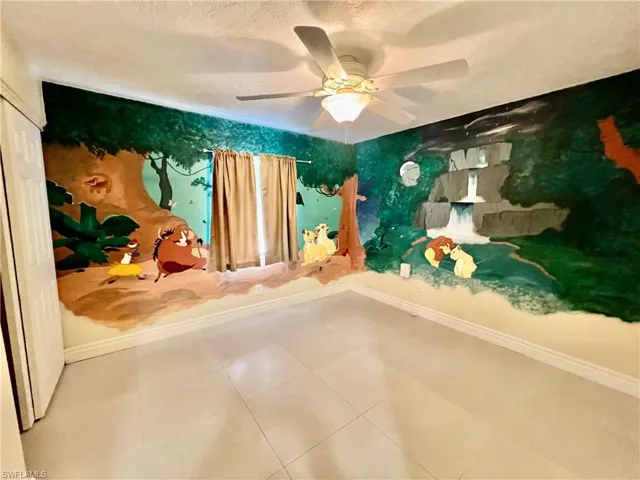 Guest bedroom featuring tile patterned flooring and a Lion King theme.