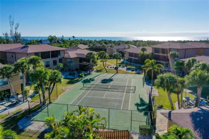 View of tennis court featuring a residential view and a patio area