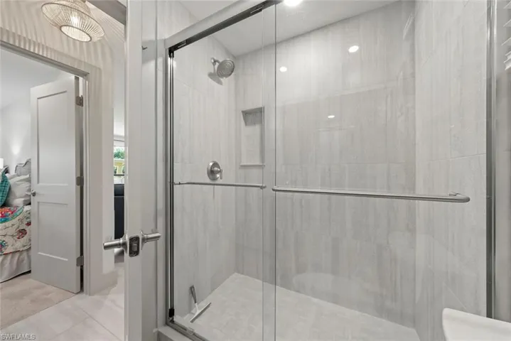 Full bathroom featuring a shower stall and connected bathroom