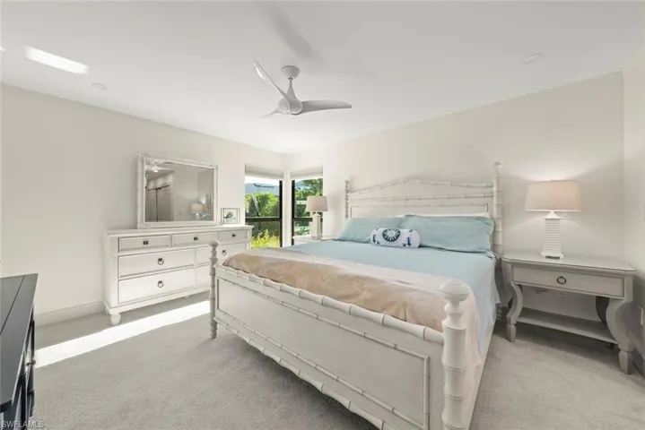 Carpeted bedroom with ceiling fan and baseboards