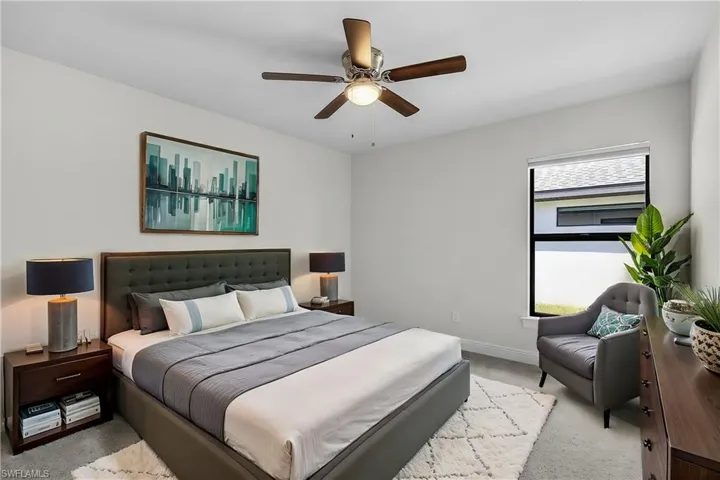 Carpeted bedroom featuring ceiling fan