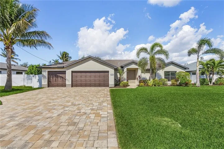 Ranch-style home featuring a front yard and a garage