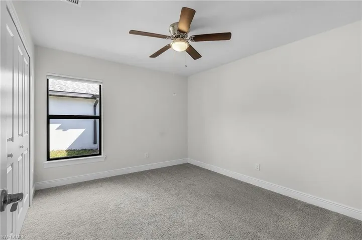 Empty room featuring ceiling fan and carpet floors