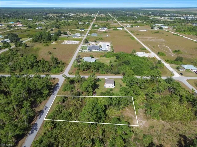 Aerial view of property and surrounding area featuring a tree filled landscape and property boundaries highlighted
