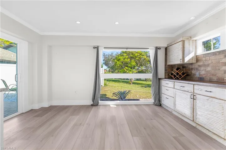 Unfurnished dining area with light wood-type flooring, plenty of natural light, and ornamental molding