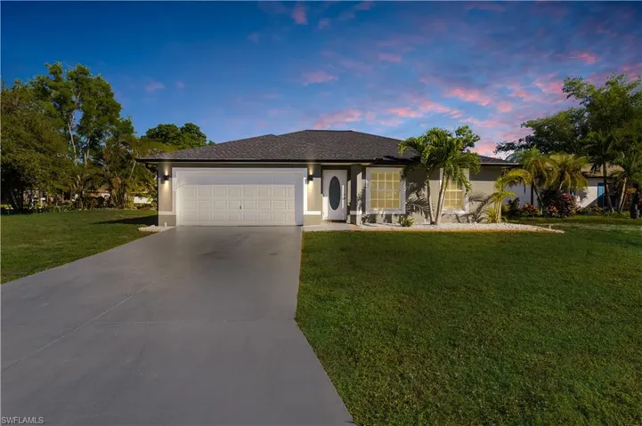 Single story home with a garage and a yard