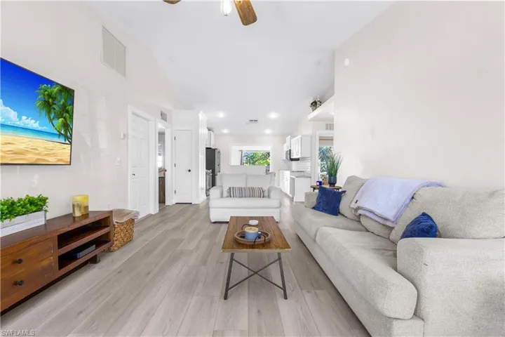 Living room featuring light hardwood / wood-style flooring, ceiling fan, and lofted ceiling