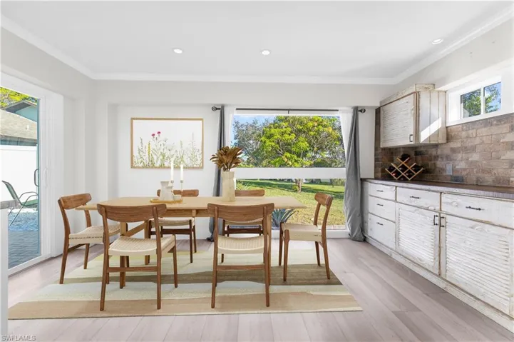 Dining room featuring light hardwood / wood-style flooring, plenty of natural light, and ornamental molding