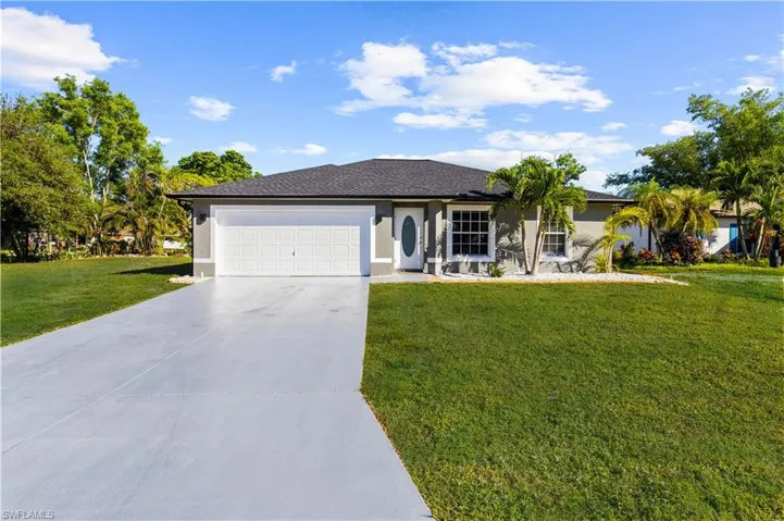 Single story home with a front yard and a garage