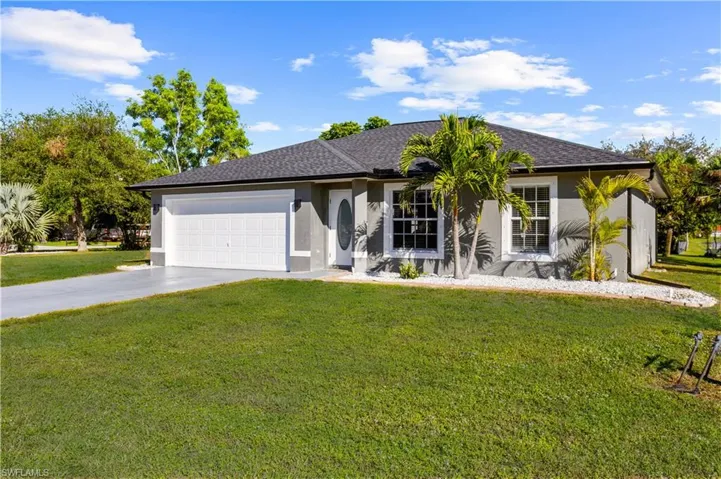 Ranch-style home featuring a front yard and a garage