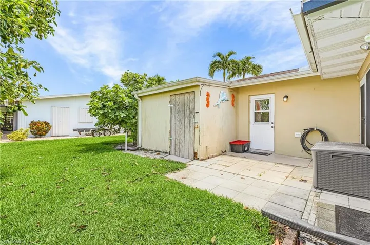 Outdoor patio for grilling with door to garage, pool area and storage room for pool toys