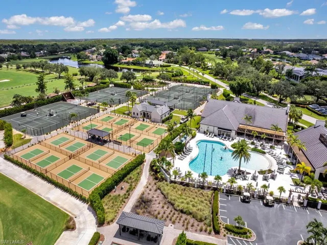 Aerial perspective of suburban area featuring a pool area and a large body of water
