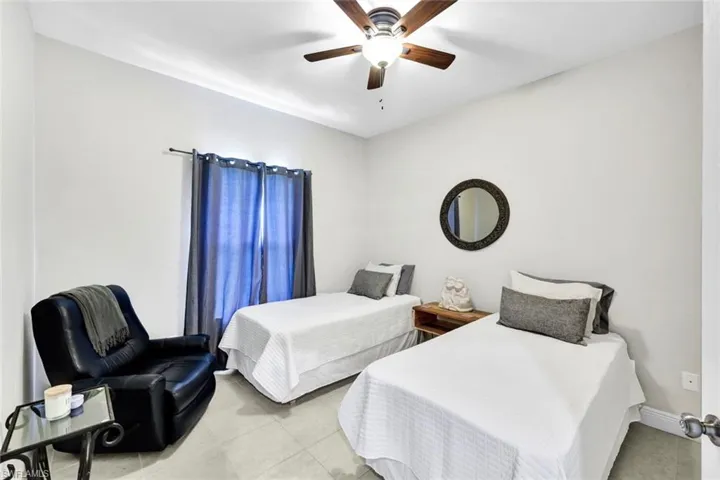 Bedroom with light tile patterned floors and ceiling fan