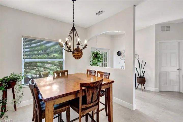 Dining area with an inviting chandelier, a healthy amount of sunlight, and light tile patterned floors